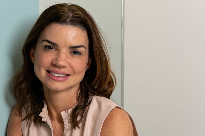 38 year old woman in her home office smiling and looking at the camera (photo 1).