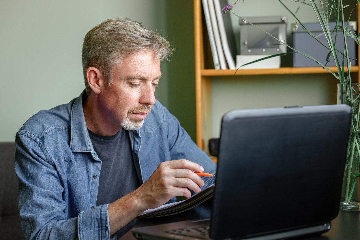 50 year old bearded man working at home office